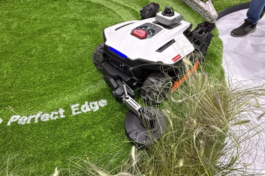 Mammotion LUBA 4 AWD mit ausgefahrenem Edge Cutting Modul an einer Rasenkante